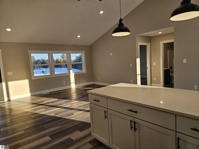 kitchen with light stone counters, high vaulted ceiling, hanging light fixtures, dark hardwood / wood-style floors, and white cabinets