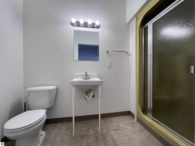 bathroom with toilet and a shower with shower door