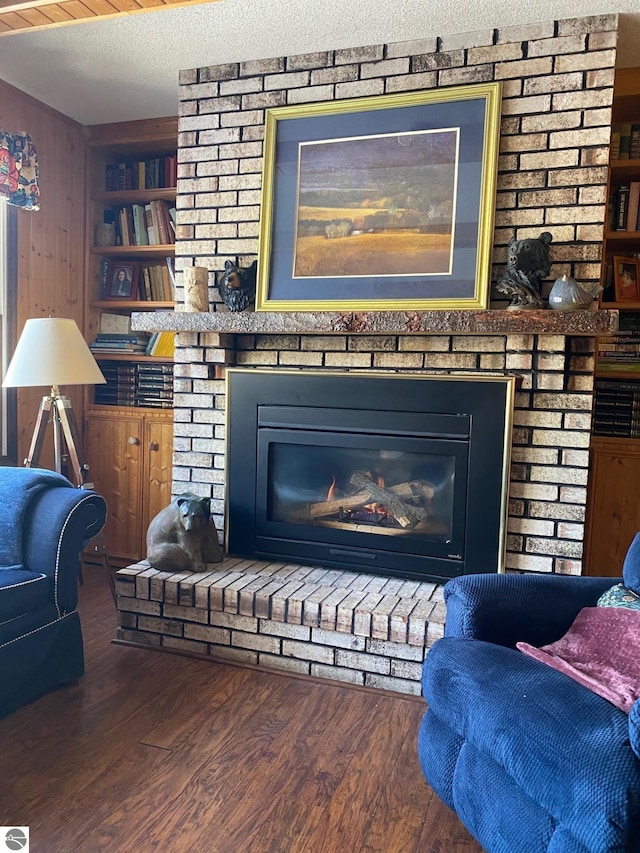 interior details with built in features, a fireplace, hardwood / wood-style floors, and a textured ceiling