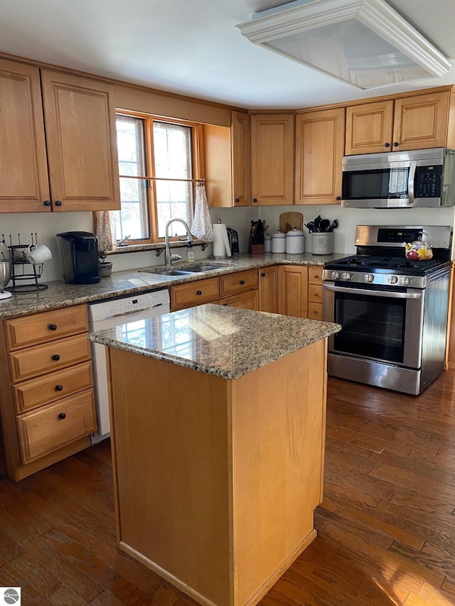 kitchen with dark wood-type flooring, stainless steel appliances, a center island, and sink