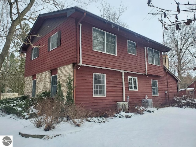 snow covered property with central air condition unit