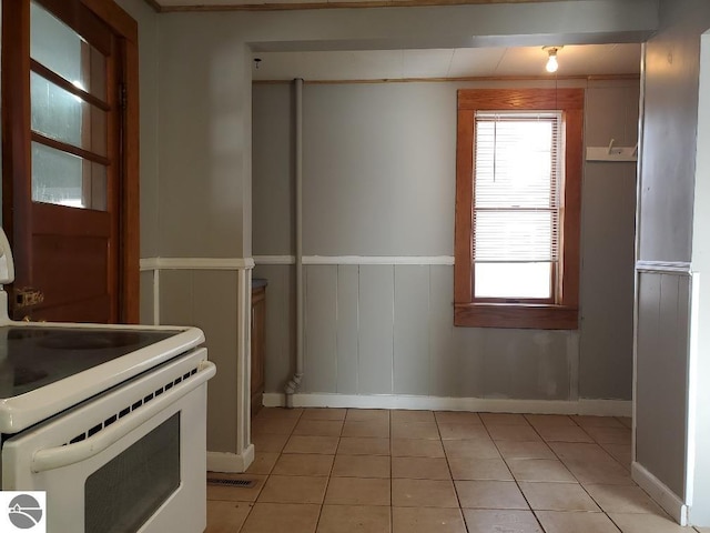 kitchen featuring light tile patterned flooring and white electric range