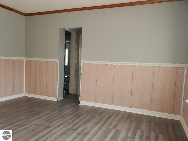 spare room featuring crown molding and dark hardwood / wood-style floors