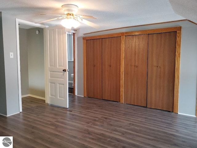 unfurnished bedroom with ceiling fan, dark wood-type flooring, and a textured ceiling