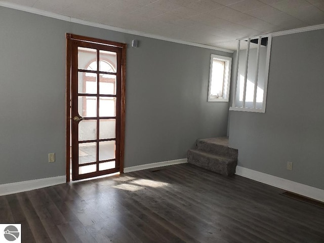 empty room with ornamental molding and dark wood-type flooring