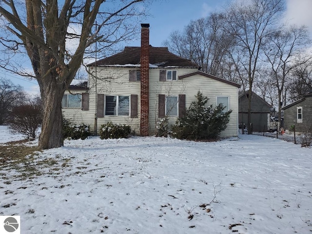 view of snow covered back of property