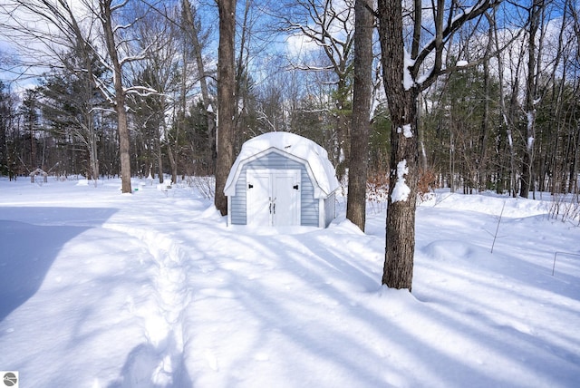 yard layered in snow with a shed