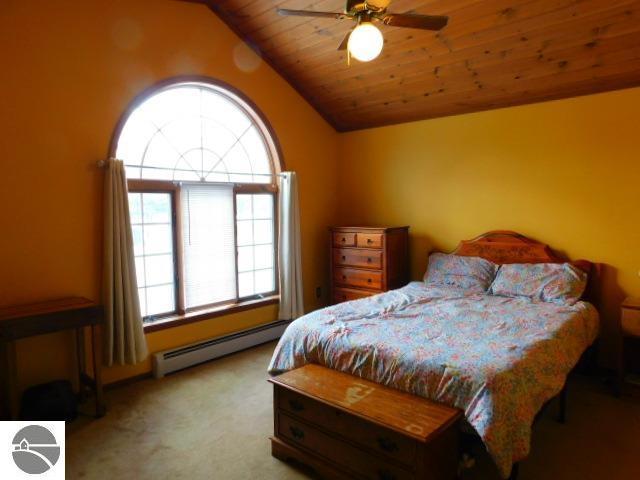 bedroom featuring light colored carpet, wooden ceiling, ceiling fan, vaulted ceiling, and baseboard heating