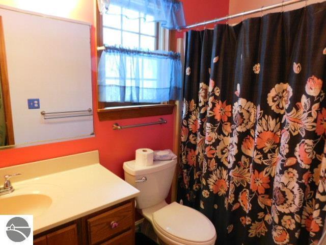 bathroom with toilet, curtained shower, and vanity