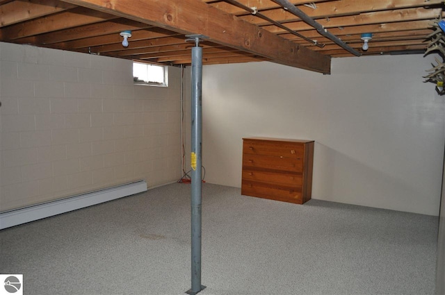 basement with a baseboard heating unit and concrete block wall