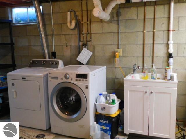 clothes washing area featuring cabinet space and washer and clothes dryer