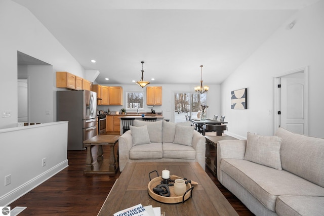 living room with dark hardwood / wood-style floors, vaulted ceiling, and a notable chandelier