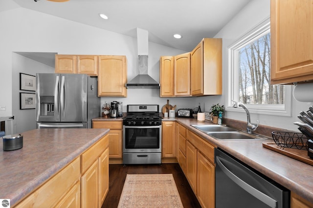 kitchen featuring lofted ceiling, sink, light brown cabinets, stainless steel appliances, and wall chimney range hood