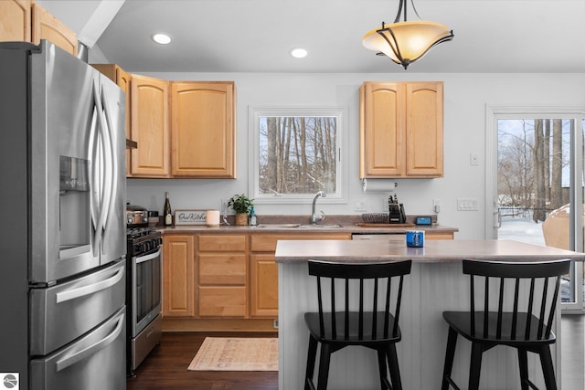 kitchen with pendant lighting, stainless steel appliances, and light brown cabinetry