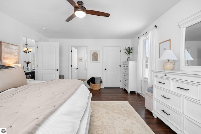 bedroom featuring ceiling fan with notable chandelier and dark hardwood / wood-style floors