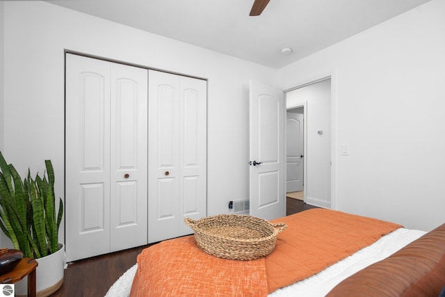 bedroom with dark hardwood / wood-style flooring, a closet, and ceiling fan