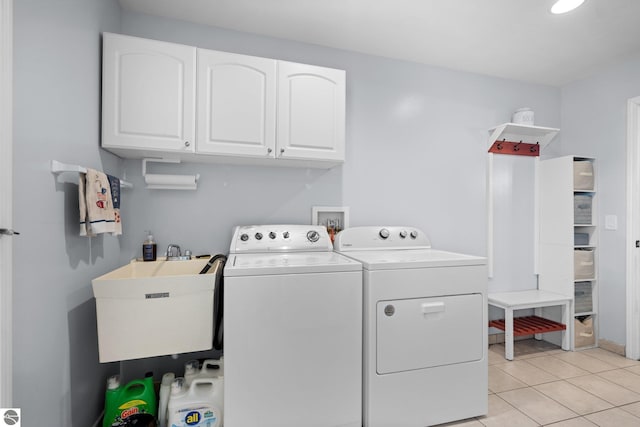 laundry room with cabinets, sink, washer and dryer, and light tile patterned floors