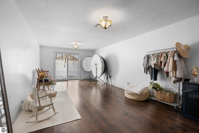 foyer entrance with dark wood-type flooring and a textured ceiling