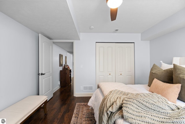 bedroom featuring ceiling fan, dark hardwood / wood-style flooring, and a closet