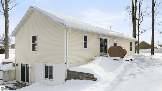 view of snow covered rear of property