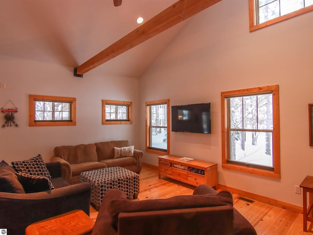 living room with plenty of natural light, beam ceiling, high vaulted ceiling, and light hardwood / wood-style flooring