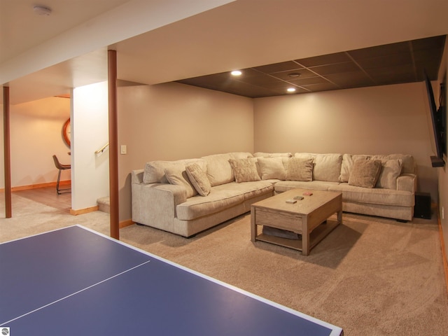 carpeted living room featuring a drop ceiling