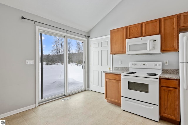 kitchen with white appliances and vaulted ceiling