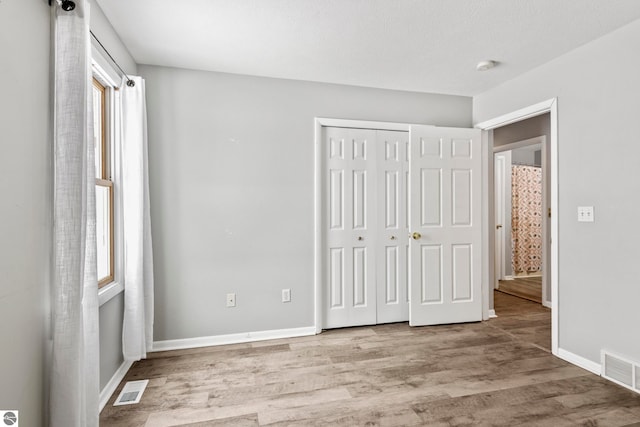 unfurnished bedroom featuring a closet and light hardwood / wood-style flooring