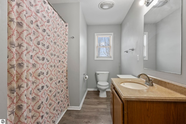 bathroom featuring hardwood / wood-style flooring, vanity, toilet, and curtained shower