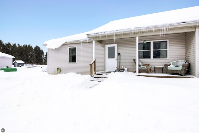 view of snow covered back of property