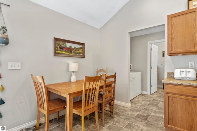 dining space with washer and clothes dryer and vaulted ceiling