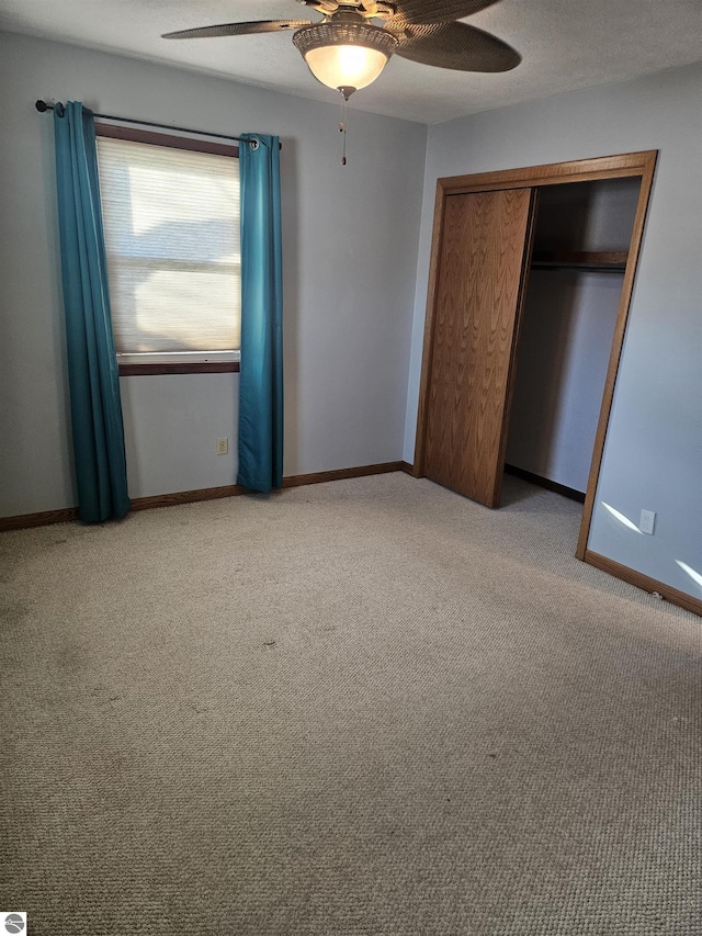 unfurnished bedroom with ceiling fan, a closet, light carpet, and a textured ceiling