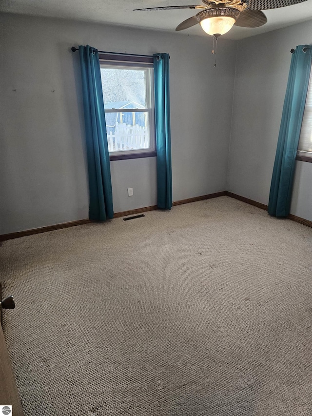 carpeted spare room featuring ceiling fan