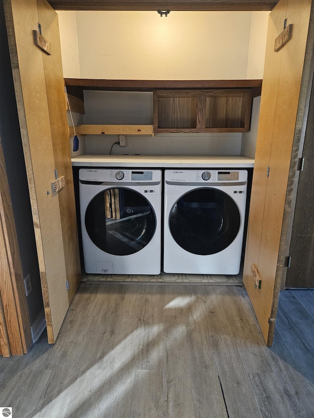 laundry area featuring hardwood / wood-style flooring and washing machine and dryer