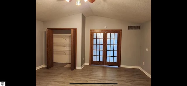 doorway to outside featuring french doors, lofted ceiling, hardwood / wood-style floors, and a textured ceiling