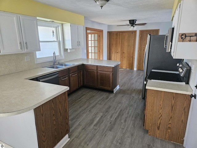 kitchen with sink, dishwasher, white cabinets, dark hardwood / wood-style flooring, and kitchen peninsula