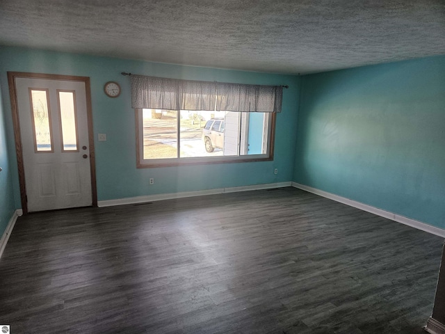 foyer entrance with dark wood-type flooring and a textured ceiling