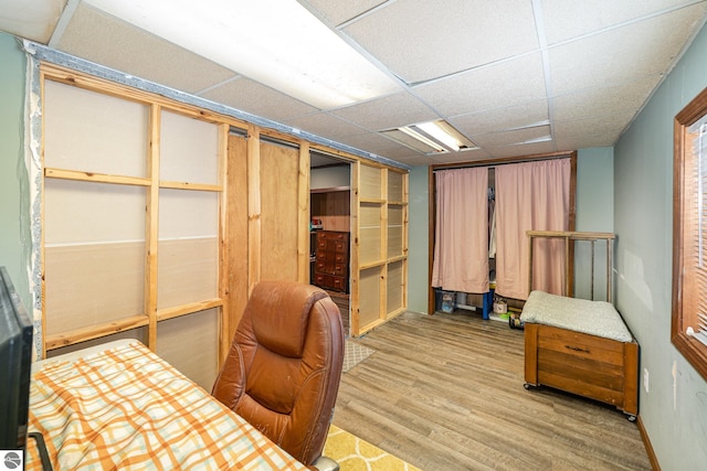 office space with a paneled ceiling and light wood-type flooring