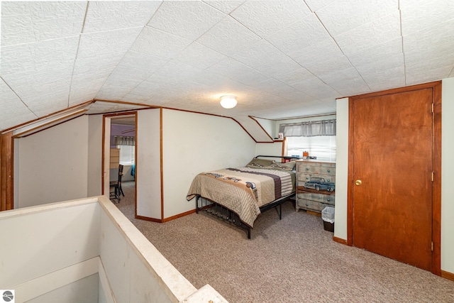 carpeted bedroom featuring vaulted ceiling and a textured ceiling