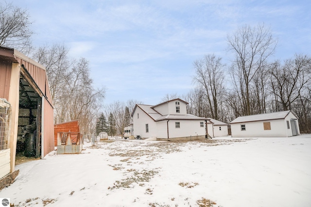 view of snowy exterior featuring an outbuilding