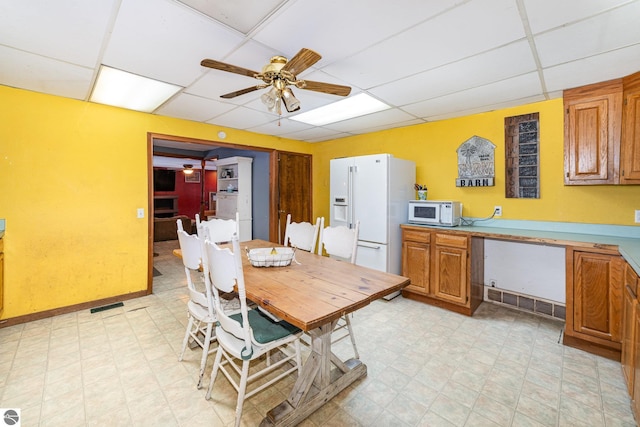 dining space with ceiling fan and a paneled ceiling