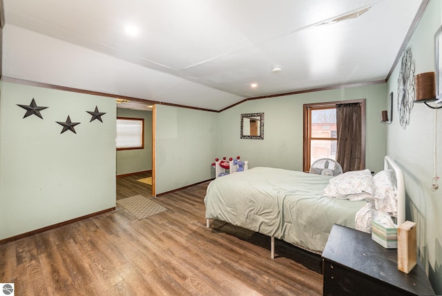 bedroom featuring crown molding, wood-type flooring, and vaulted ceiling