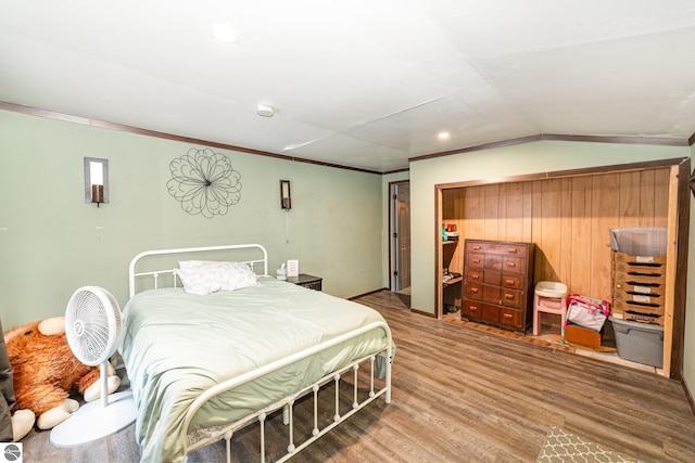 bedroom featuring crown molding, lofted ceiling, and hardwood / wood-style floors