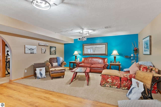 living room with wood-type flooring and a textured ceiling