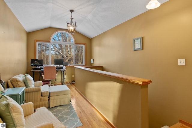 office space featuring vaulted ceiling, an inviting chandelier, and light wood-type flooring