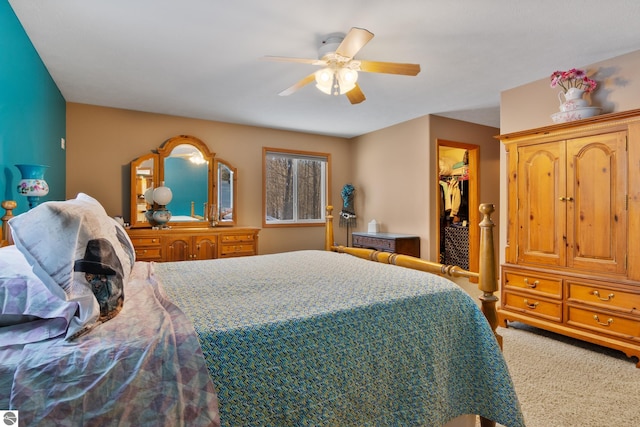 carpeted bedroom featuring a spacious closet and ceiling fan