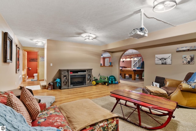 living room featuring billiards, hardwood / wood-style floors, and a textured ceiling