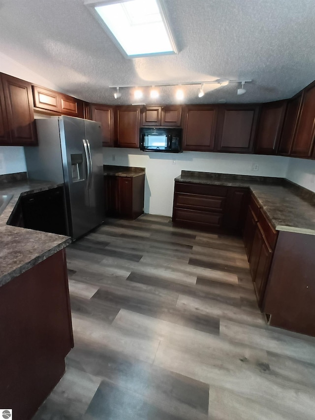 kitchen featuring hardwood / wood-style flooring, stainless steel fridge, and a textured ceiling