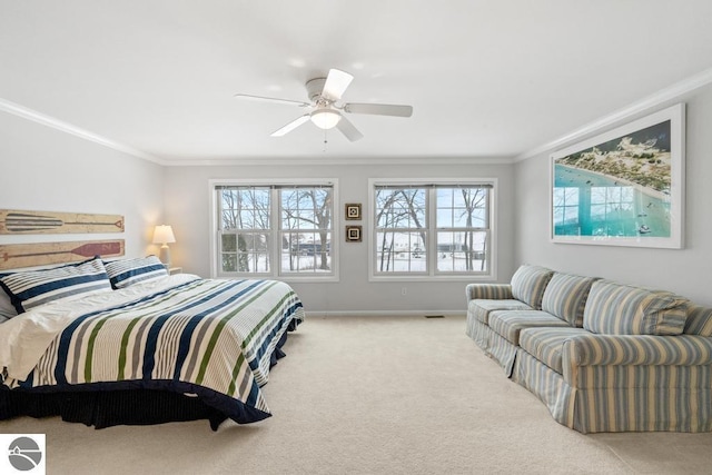 carpeted bedroom with ornamental molding and ceiling fan