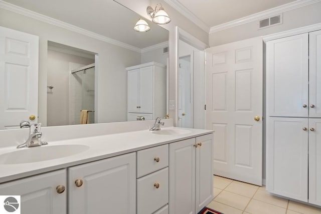 bathroom featuring ornamental molding, a shower with shower door, tile patterned flooring, and vanity